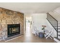 Inviting living room featuring a fireplace, stairs, and light wood-look floors at 1620 S Ivory Cir # C, Aurora, CO 80017