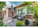 Relaxing backyard stone patio featuring comfortable seating, an umbrella, and lush landscaping at 2552 E Alameda Ave # 74, Denver, CO 80209