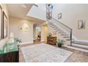 Bright and airy foyer featuring hardwood floors, a staircase with iron railing, and a modern chandelier at 2552 E Alameda Ave # 74, Denver, CO 80209