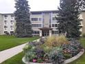 Attractive condominium building with landscaped flower bed in front of entry at 9180 E Center Ave # 9D, Denver, CO 80247