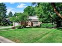 Lovely home featuring a lush green lawn with mature trees in a quiet neighborhood at 56 Spyglass Dr, Littleton, CO 80123