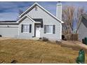 Charming home featuring gray siding, black shutters, and a well-manicured lawn at 17605 E Temple Dr, Aurora, CO 80015