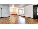 Bright living room with wood floors, large window, chandelier, and white walls at 6340 Quay St, Arvada, CO 80003