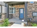 Charming front porch showcases stone detailing, modern blue door, and an inviting entrance at 6350 N Lisbon St, Aurora, CO 80019