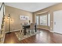 Elegant dining room with hardwood floors, bay window, and a black dining table at 9898 Mulberry Way, Highlands Ranch, CO 80129