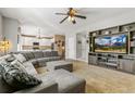 Comfortable living room with plush sectional, built-in shelving, and a view into the bright kitchen at 9898 Mulberry Way, Highlands Ranch, CO 80129