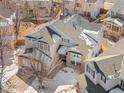 Aerial view of a well-maintained, two story home with a brick-accented front, snow covered back yard, and attached garage at 13277 Elizabeth St, Thornton, CO 80241