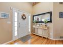 Bright foyer with hardwood floors, decorative mirror, and a welcoming front door at 13277 Elizabeth St, Thornton, CO 80241
