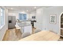 Bright, eat-in kitchen featuring white cabinets, stainless steel appliances, and stone countertops at 23721 E 40Th Ave, Aurora, CO 80019