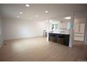 Bright, open-concept space with modern lighting, sleek floors, and a stylish kitchen with breakfast bar at 1552 S Fairplay Way, Aurora, CO 80012