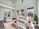 Bright living room features soaring ceilings, many windows, and stylish neutral decor at 2245 Whistler Dr, Longmont, CO 80504