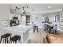 Open-concept kitchen featuring an island with bar seating, stainless appliances, and modern lighting at 2151 Enterprise St, Superior, CO 80027