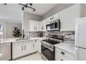 Bright kitchen featuring white cabinetry, stainless steel appliances and modern backsplash at 2151 Enterprise St, Superior, CO 80027
