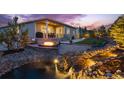 Beautiful backyard featuring a water feature, firepit, patio, covered porch and mature trees, professionally landscaped at 4213 Hickory Oaks St, Castle Rock, CO 80104