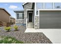 Close-up of the front entrance showing stone accents and mature shrubs at 5417 Riverbend Ave, Firestone, CO 80504