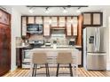 Modern kitchen with stainless steel appliances, island, and hardwood floors at 740 N Sherman St # 107, Denver, CO 80203