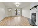 Inviting living room featuring wood floors, a brick fireplace, and a bright window at 11935 E Ford Dr, Aurora, CO 80012