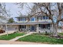 Beautiful two-story home featuring a well-kept lawn, flowerbeds, and an inviting front porch area at 8029 W Hoover Pl, Littleton, CO 80123