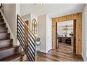 Inviting foyer with hardwood floors, modern staircase, and wood framed office entrance at 8029 W Hoover Pl, Littleton, CO 80123