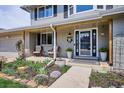 Inviting front porch with comfortable seating and beautifully landscaped garden for relaxing outdoors at 8029 W Hoover Pl, Littleton, CO 80123