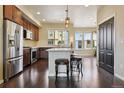 Open kitchen featuring stainless steel appliances, a center island with seating, and hardwood flooring at 2505 S Orion St, Lakewood, CO 80228