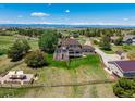 Expansive aerial view of the property, showcasing a large yard, patio area, and mature trees at 8184 S Ireland Way, Aurora, CO 80016