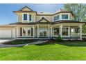 Elegant home with a covered porch, manicured lawn, large windows, and lush landscaping at 8184 S Ireland Way, Aurora, CO 80016
