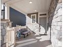Cozy front porch features stone columns and a comfortable seating area to relax at 21901 E 42Nd Place, Aurora, CO 80019