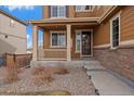 Inviting front porch with stone accents, columns, and manicured landscaping leading to the home's entrance at 11828 Churchfield St, Parker, CO 80134