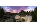 Charming home with a cozy porch and well-lit windows, set against a backdrop of a colorful sunset sky at 116 N Gilbert St, Castle Rock, CO 80104