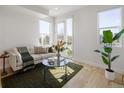 Bright living room with hardwood floors, a comfortable sofa, and a balcony with city views at 1810 Irving St # 8, Denver, CO 80204