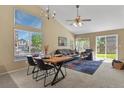 Bright and open living room with dining area, large windows, and stylish furnishings at 9860 Burberry Way, Highlands Ranch, CO 80129