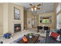 Spacious living room featuring a fireplace, seamless flow to the dining area, and natural light at 9860 Burberry Way, Highlands Ranch, CO 80129