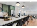 Modern kitchen features sleek countertops, stainless steel appliances, and olive green cabinetry at 3285 Lawrence St, Denver, CO 80205