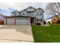 Two-story home showing a well-maintained lawn and a spacious three car driveway at 9275 Erminedale Dr, Lone Tree, CO 80124