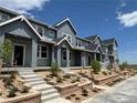 Street view of modern gray townhouses with concrete steps and manicured front yards with retaining walls and fresh landscaping at 17137 W 91St Ln, Arvada, CO 80007