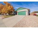 Ranch home with a green door and large tree in the front yard at 1040 S Fulton Ave, Fort Lupton, CO 80621