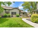 Exterior view of a home with a green lawn, mature trees, and sidewalk at 9183 W Cedar Dr # 2, Lakewood, CO 80226
