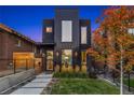 Modern black home with large windows, green lawn, and attractive landscaping at 3709 Tejon St, Denver, CO 80211