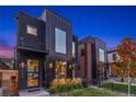 Stylish home featuring black siding, a modern design, manicured landscaping, and ample natural light through its large windows at 3709 Tejon St, Denver, CO 80211