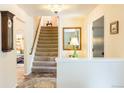 Inviting entryway featuring tiled floors, staircase, and decorative mirror at 7150 S Curtice St, Littleton, CO 80120