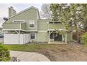 View of the back exterior of the green home with a small yard area at 4162 S Richfield S Way, Aurora, CO 80013