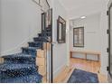 Entryway with wood floors, stairs with blue carpet, a bench, and a decorative mirror at 1265 S Gaylord St, Denver, CO 80210