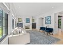 Bright living room with a fireplace, gray sofa, blue chairs, and large windows with white shutters at 1265 S Gaylord St, Denver, CO 80210