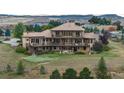 Aerial view of a home with multiple decks overlooking a putting green and spacious backyard at 8871 Aspen Leaf Ct, Littleton, CO 80125