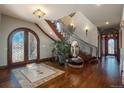 Grand foyer showcasing hardwood floors, staircase, decorative mirror, and elegant lighting fixtures at 8871 Aspen Leaf Ct, Littleton, CO 80125