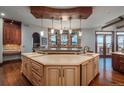 Custom kitchen featuring stone accent wall, large island, and scenic views at 8871 Aspen Leaf Ct, Littleton, CO 80125