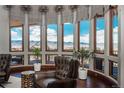 Living room featuring oversized windows with mountain views, hardwood floors, and comfortable seating at 8871 Aspen Leaf Ct, Littleton, CO 80125