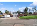Charming split-level home featuring a two-car garage, brick accents, and a well-maintained front lawn at 11600 W 31St Pl, Lakewood, CO 80215
