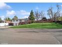 A well-maintained split-level home with a spacious front yard and mature trees providing shade and curb appeal at 11600 W 31St Pl, Lakewood, CO 80215